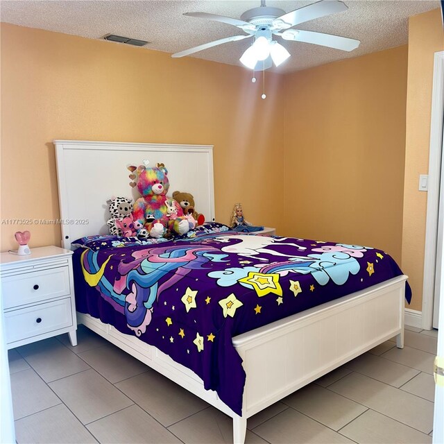 1950 S Tanner Rd, Orlando, FL 32820 - bedroom featuring light tile patterned floors, a textured ceiling, and a ceiling fan
