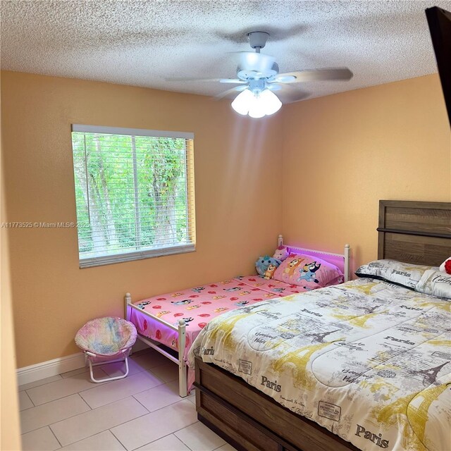 1950 S Tanner Rd, Orlando, FL 32820 - bedroom with light tile patterned floors, a ceiling fan, and a textured ceiling