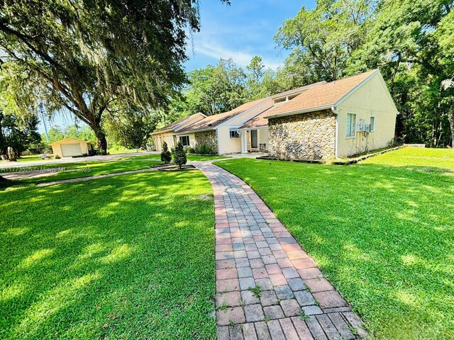 1950 S Tanner Rd, Orlando, FL 32820 - view of front of property featuring stone siding, a front lawn, a garage, and stucco siding