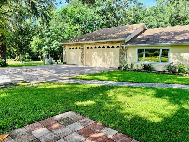 1950 S Tanner Rd, Orlando, FL 32820 - ranch-style home with a garage, a front lawn, asphalt driveway, and stone siding