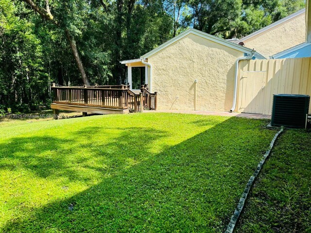 1950 S Tanner Rd, Orlando, FL 32820 - view of grassy yard featuring a deck and central air condition unit