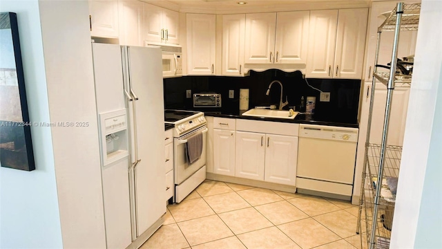 1950 S Ocean Dr Unit 6G, Hallandale Beach, FL 33009 - kitchen with white appliances, a sink, dark countertops, white cabinetry, and light tile patterned flooring