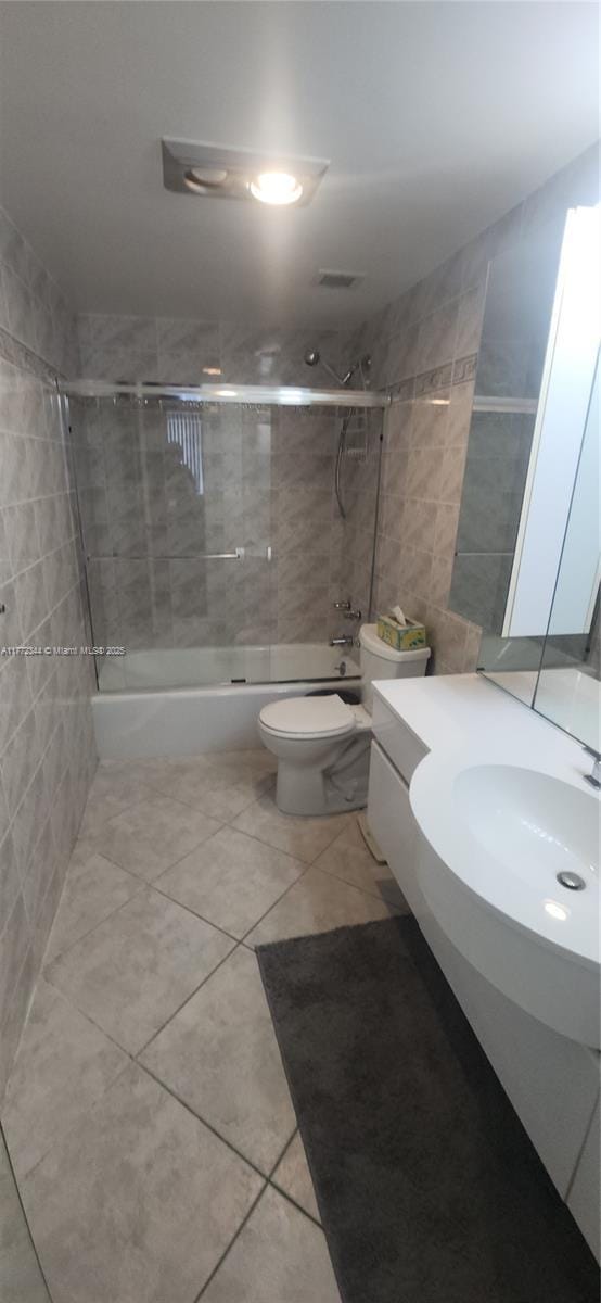 1950 S Ocean Dr Unit 6G, Hallandale Beach, FL 33009 - full bath featuring combined bath / shower with glass door, tile patterned floors, vanity, toilet, and tile walls