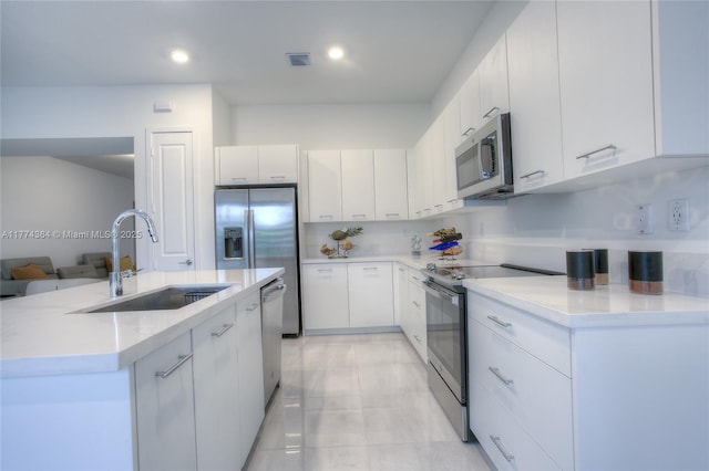 17451 SW 41st St, Miramar, FL 33029 - kitchen featuring appliances with stainless steel finishes, a sink, a kitchen island with sink, white cabinetry, and light countertops