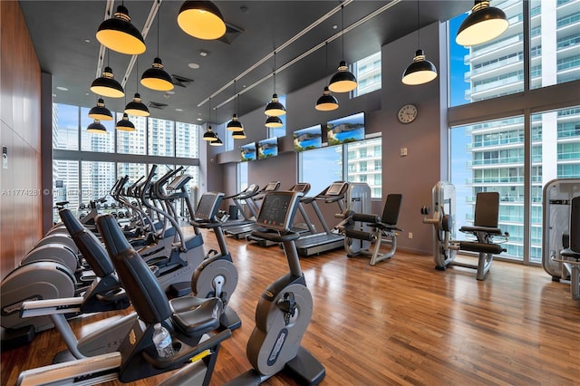 1300 Brickell Bay Dr Unit 601, Miami, FL 33131 - exercise room with visible vents, a high ceiling, and wood finished floors