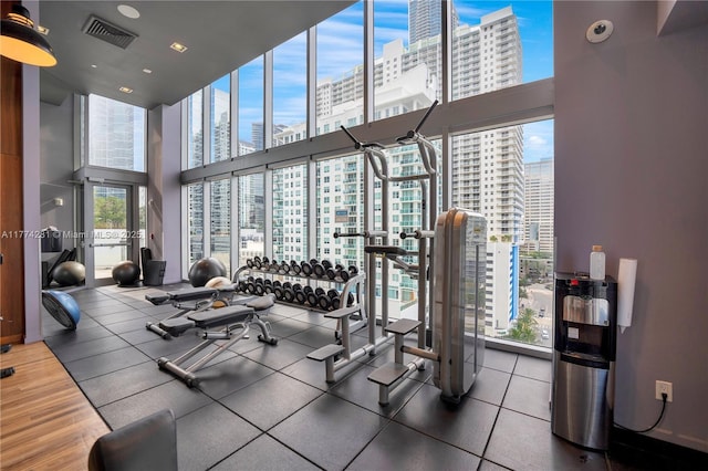1300 Brickell Bay Dr Unit 601, Miami, FL 33131 - gym with expansive windows, visible vents, a city view, and a towering ceiling