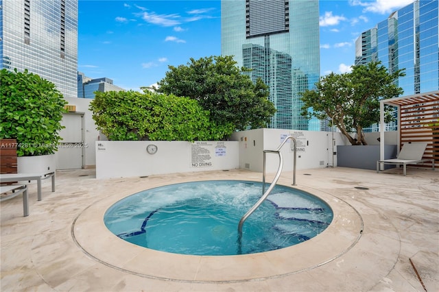 1300 Brickell Bay Dr Unit 601, Miami, FL 33131 - view of swimming pool with a hot tub, a view of city, fence, and a patio area