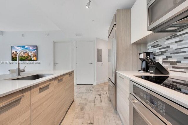 1300 Brickell Bay Dr Unit 601, Miami, FL 33131 - kitchen with modern cabinets, stainless steel appliances, and tasteful backsplash