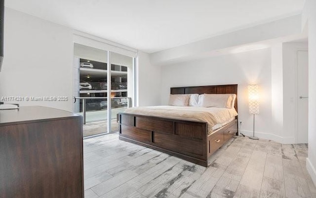 1300 Brickell Bay Dr Unit 601, Miami, FL 33131 - bedroom featuring baseboards, access to outside, floor to ceiling windows, and light wood finished floors