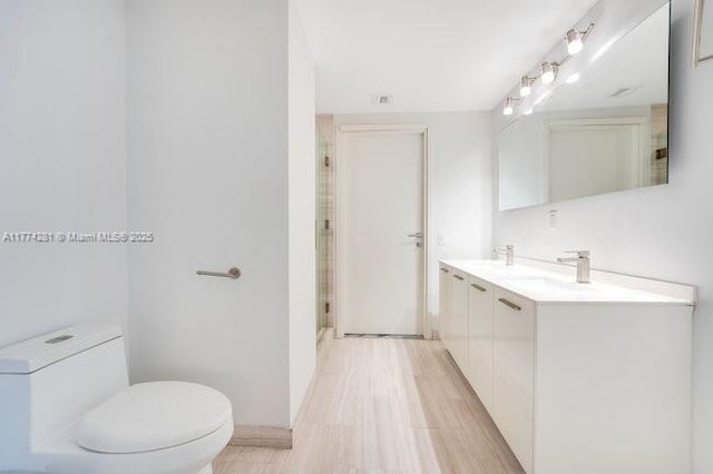 1300 Brickell Bay Dr Unit 601, Miami, FL 33131 - bathroom with vanity, wood finished floors, toilet, and a shower stall