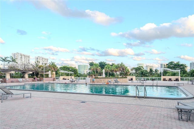 community pool with a view of city and a patio area