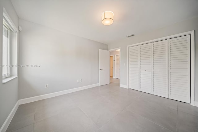 6881 SW 94th Ave, Miami, FL 33173 - unfurnished bedroom featuring a closet, baseboards, and tile patterned flooring