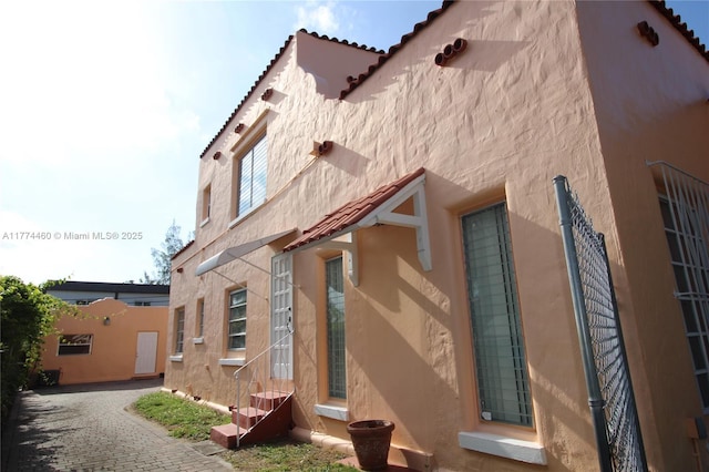 view of side of property with entry steps and stucco siding