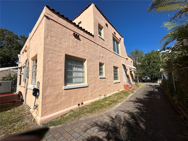 view of property exterior with central air condition unit and stucco siding