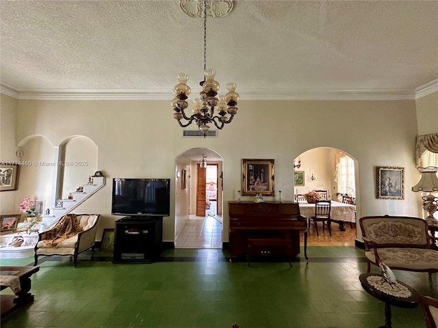 living room featuring a chandelier, arched walkways, visible vents, and a textured ceiling
