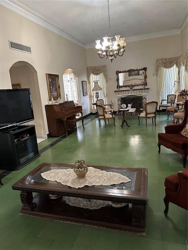 living room with baseboards, an inviting chandelier, ornamental molding, visible vents, and arched walkways
