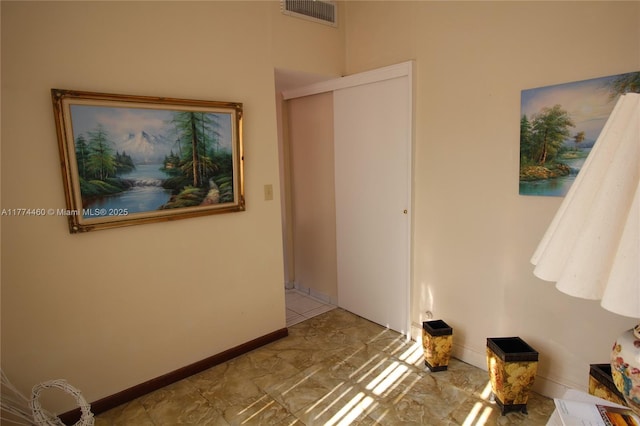 corridor with baseboards and visible vents
