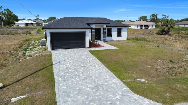 3114 39th St SW, Lehigh Acres, FL 33976 - view of front of house featuring stucco siding, an attached garage, decorative driveway, a front yard, and a shingled roof