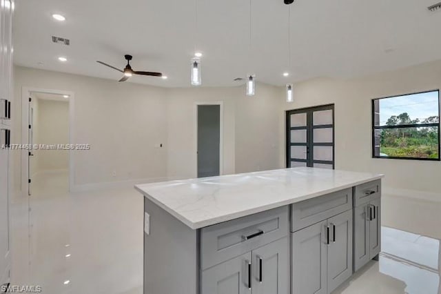 3114 39th St SW, Lehigh Acres, FL 33976 - kitchen with a ceiling fan, a center island, gray cabinetry, visible vents, and decorative light fixtures
