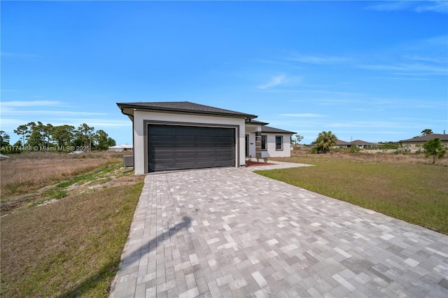 3114 39th St SW, Lehigh Acres, FL 33976 - view of front of property featuring stucco siding, a garage, a front yard, and decorative driveway