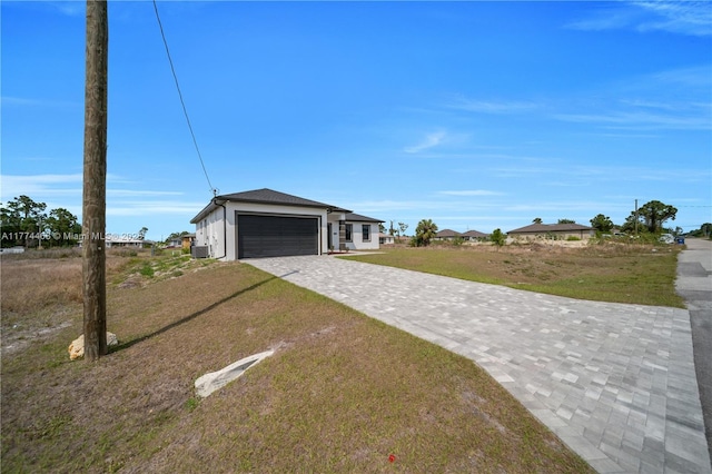 3114 39th St SW, Lehigh Acres, FL 33976 - view of front facade featuring stucco siding, decorative driveway, a garage, and a front lawn