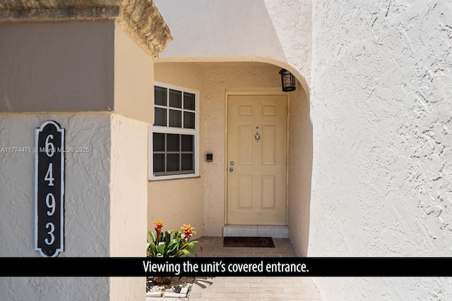 doorway to property with stucco siding