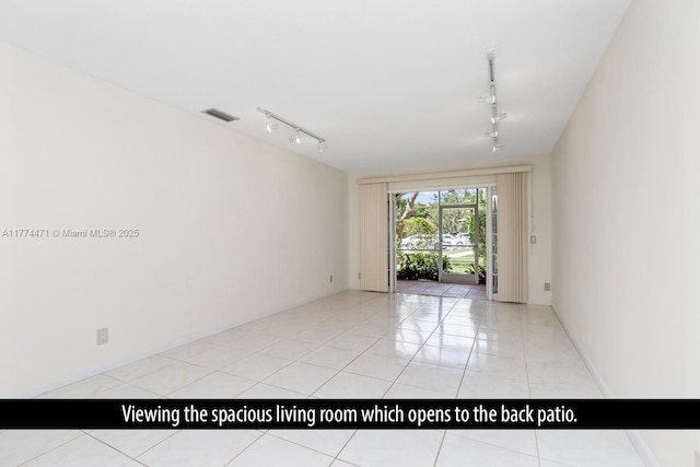 spare room featuring light tile patterned flooring, visible vents, and track lighting