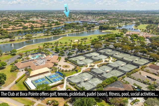 drone / aerial view featuring golf course view and a water view