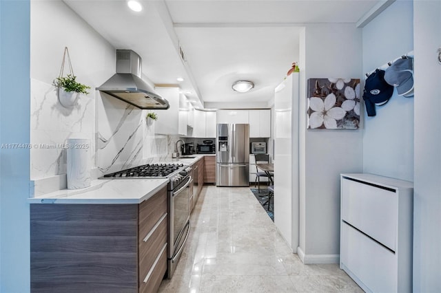kitchen featuring white cabinetry, backsplash, modern cabinets, appliances with stainless steel finishes, and range hood