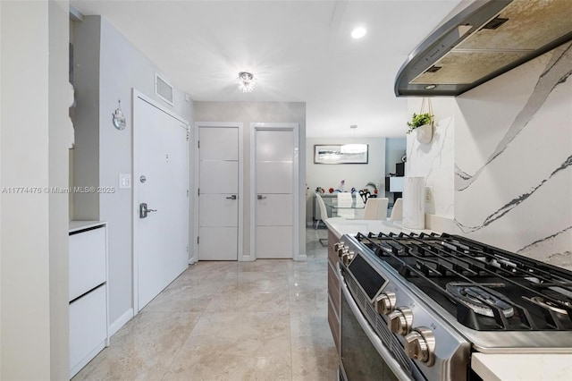 kitchen featuring visible vents, stainless steel gas range oven, and light countertops