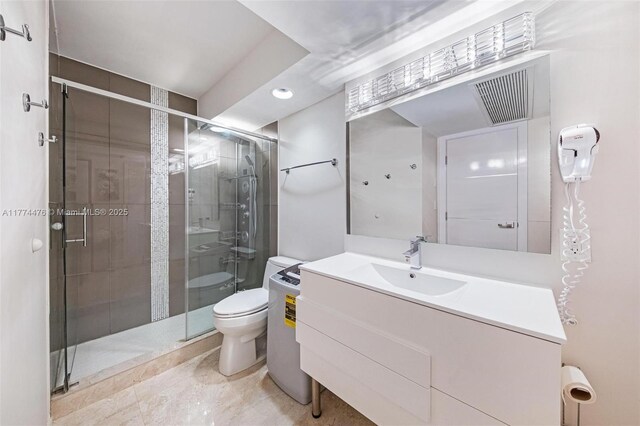 bathroom with toilet, a shower stall, and vanity