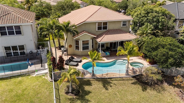 16473 SW 30th St, Miramar, FL 33027 - back of property with an in-ground hot tub, stucco siding, a fenced backyard, and a tiled roof