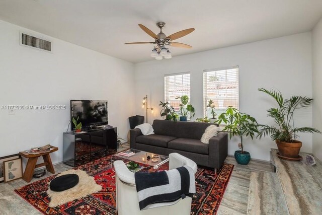 living area featuring visible vents and a ceiling fan