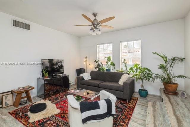 carpeted living room featuring a ceiling fan and visible vents