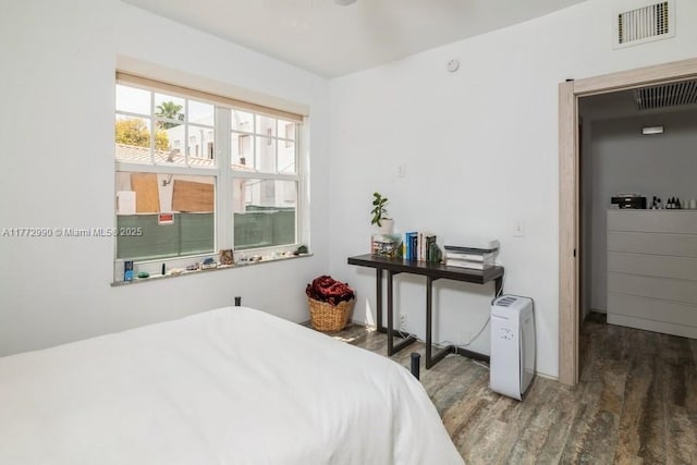bedroom featuring wood finished floors, visible vents, and baseboards
