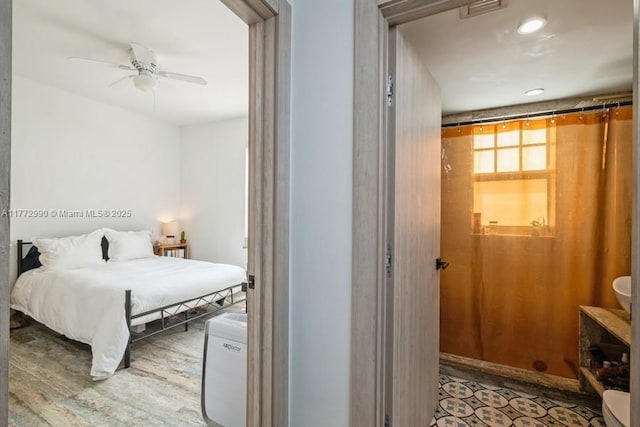 bedroom with a ceiling fan, visible vents, and wood finished floors