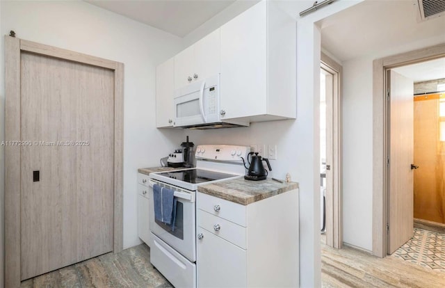 kitchen featuring light wood finished floors, visible vents, white cabinetry, and white appliances