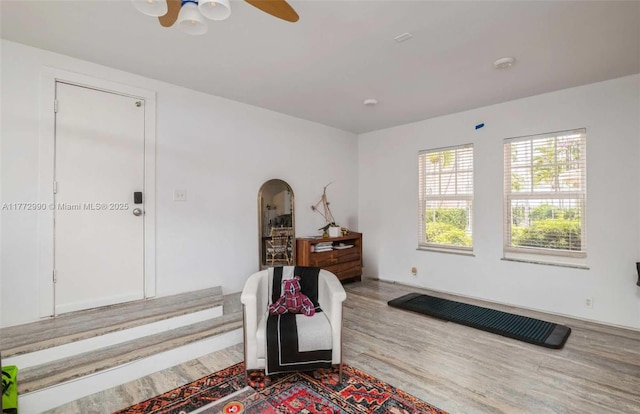 bedroom with arched walkways and wood finished floors