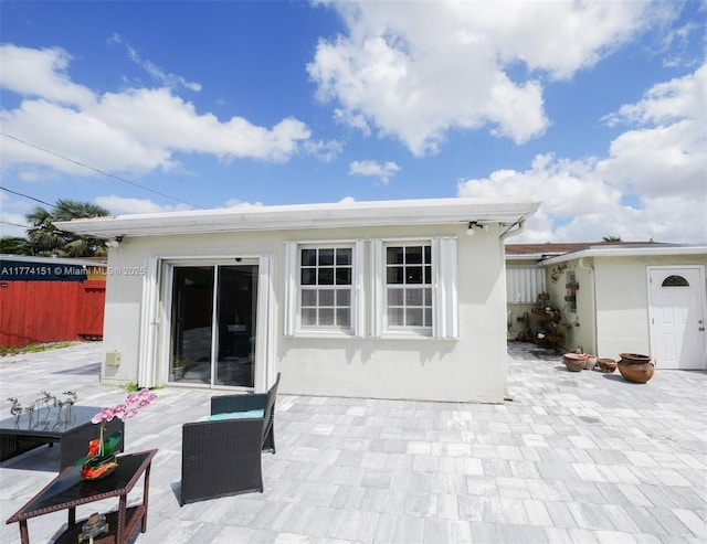 8110 NW 185th Ter, Hialeah, FL 33015 - rear view of property featuring a patio, stucco siding, fence, and an outbuilding