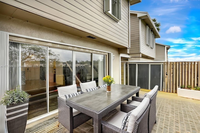 view of patio featuring outdoor dining area and fence