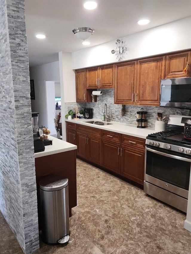 kitchen featuring light countertops, decorative backsplash, a sink, and stainless steel appliances
