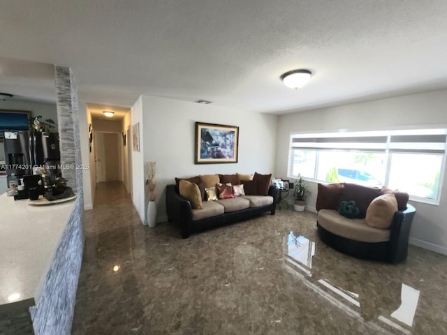 living room featuring visible vents, baseboards, and a textured ceiling