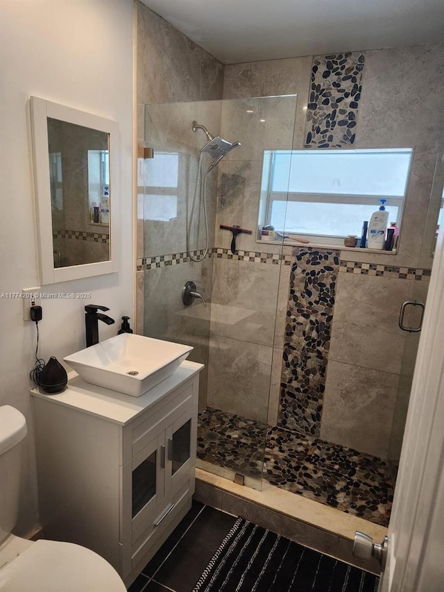 bathroom with tile patterned floors, vanity, walk in shower, and toilet