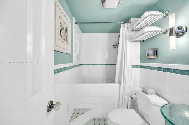 bathroom with tile walls, visible vents, and toilet