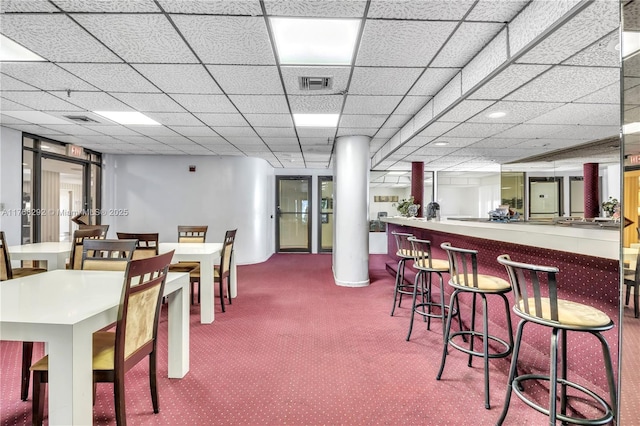 dining area featuring visible vents, carpet flooring, and a community bar