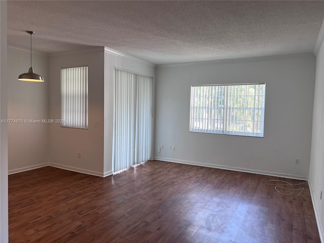 unfurnished room with baseboards, ornamental molding, dark wood-style floors, and a textured ceiling