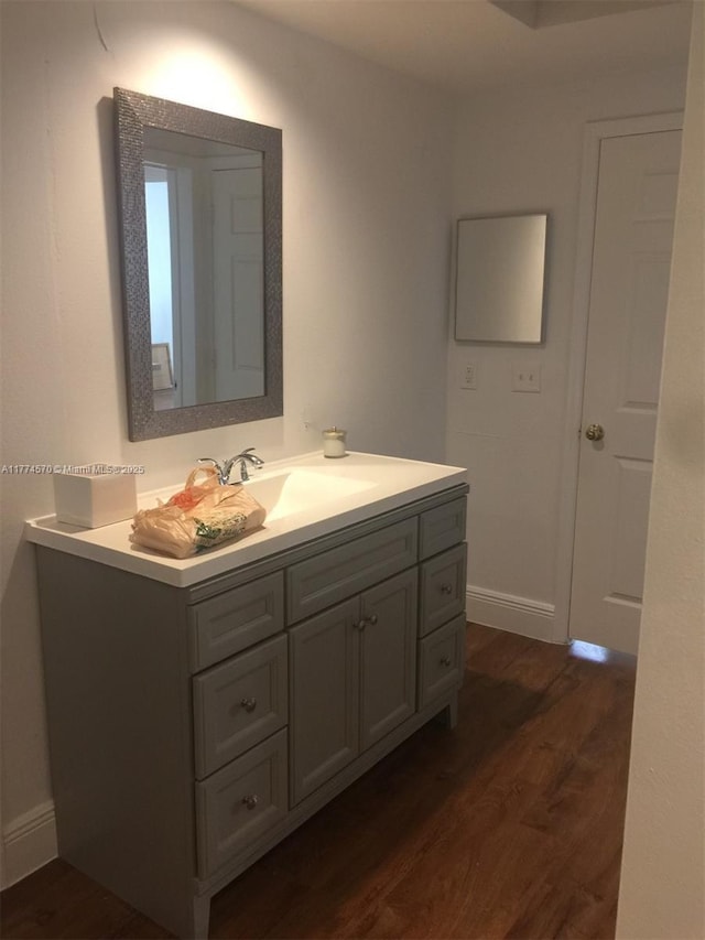 bathroom with vanity, baseboards, and wood finished floors