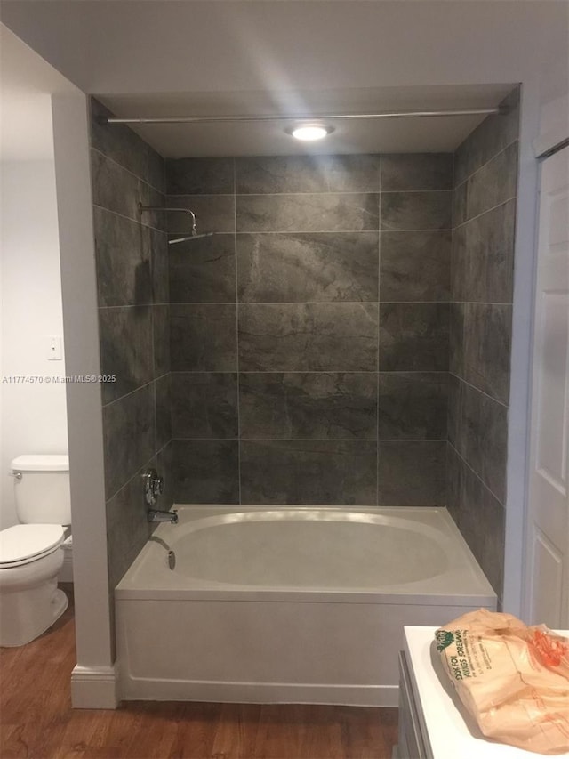 bathroom featuring shower / bathtub combination, toilet, and wood finished floors
