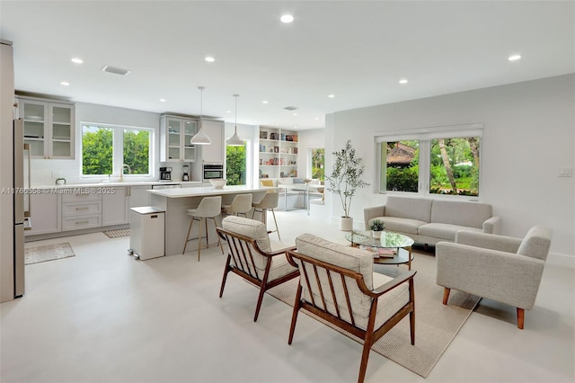 living area featuring recessed lighting, visible vents, and a wealth of natural light