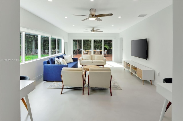 living area featuring ceiling fan, recessed lighting, and concrete flooring
